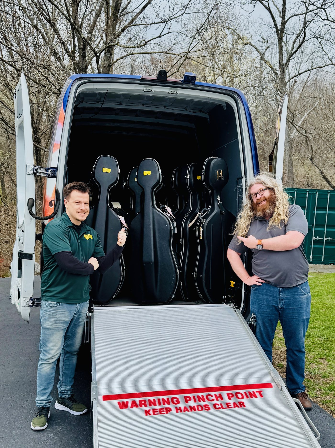 Two of our team loading cello cases into the delivery van