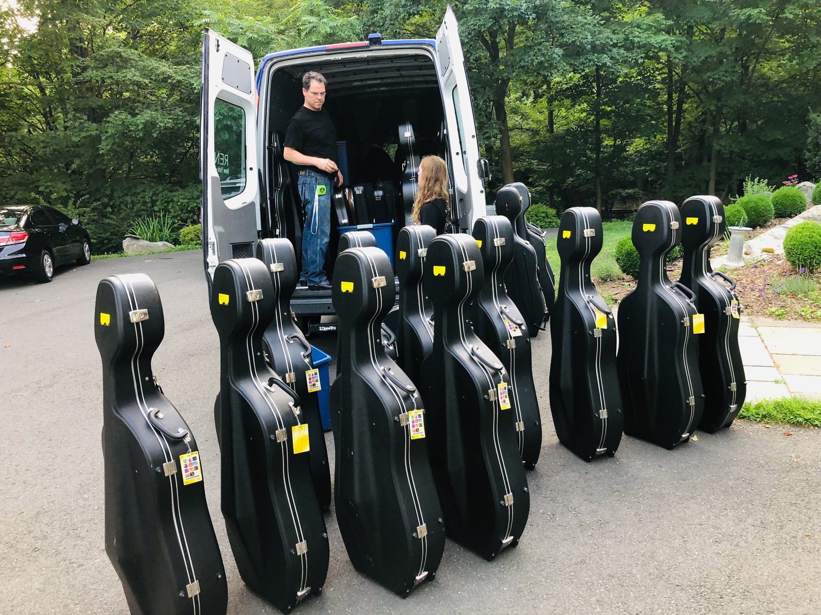 Cellos staged beside the van for a school delivery