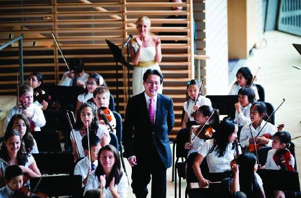 Founder Kenneth Kuo with a student string orchestra