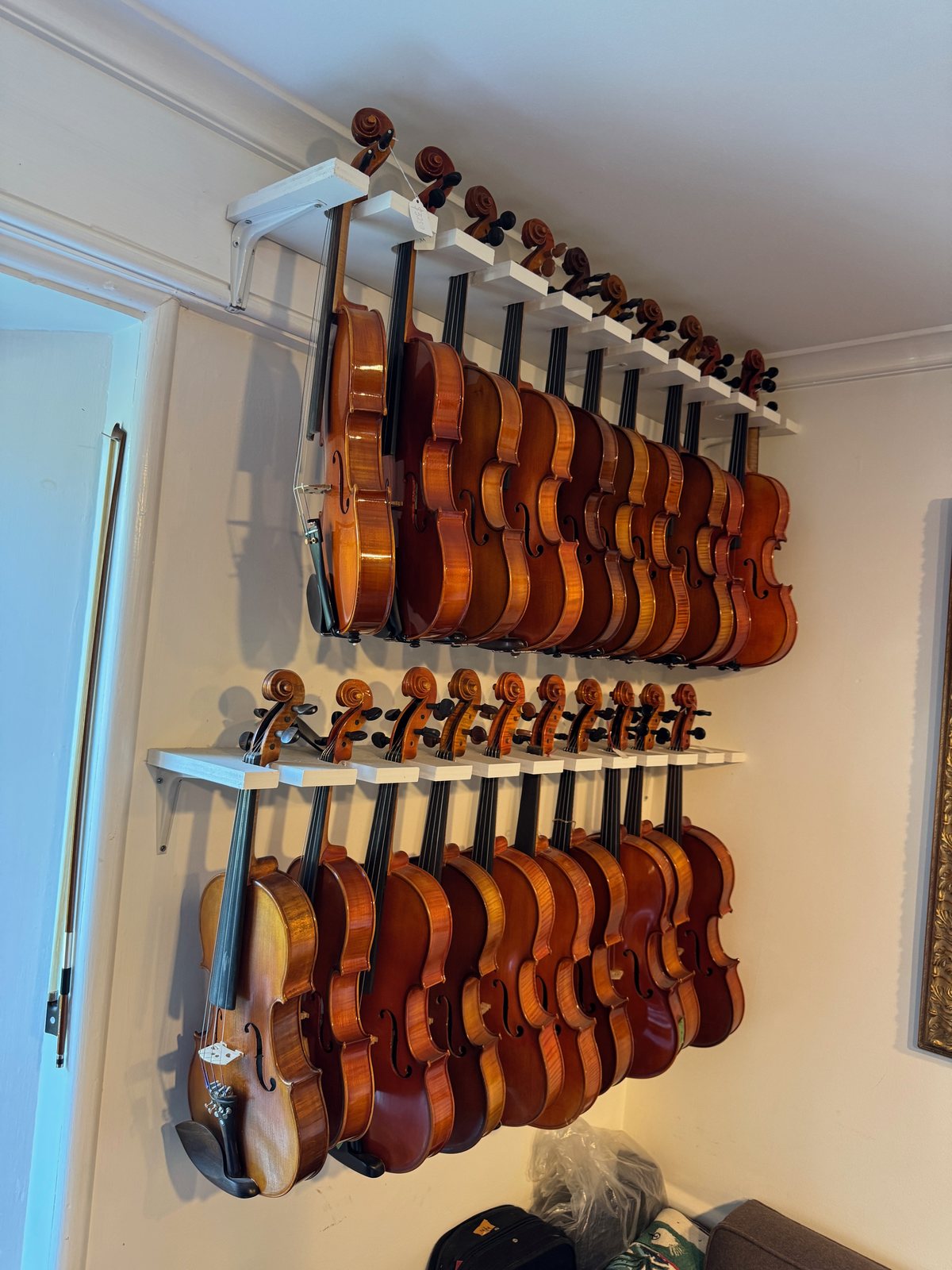 Violins on the wall in Norwalk, ready to be fitted
